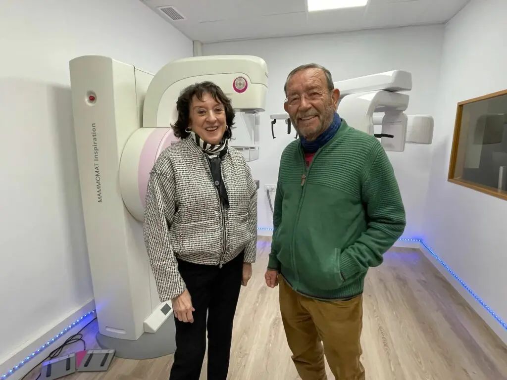 Dos personas en la sala de radiología del centro, junto al mamógrafo