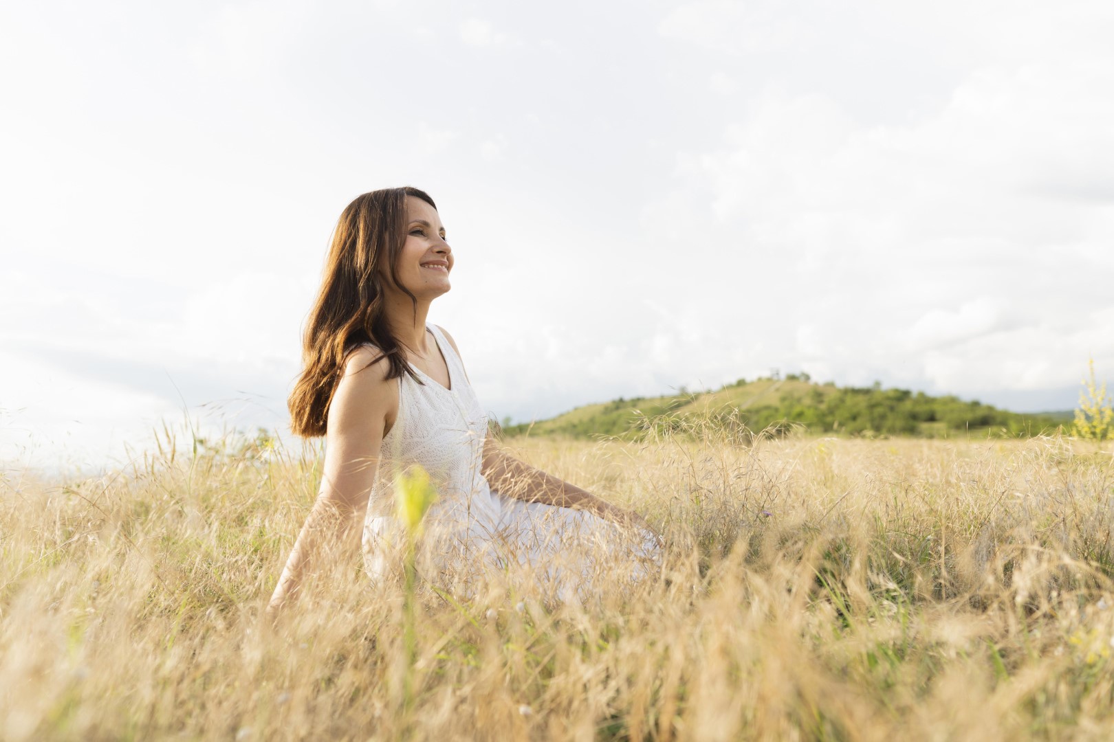 Mujer sonriente sentada en un campo