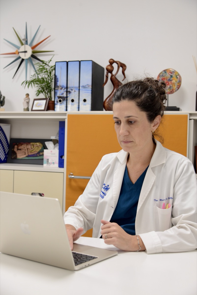 Médica trabajando con el ordenador en su consulta