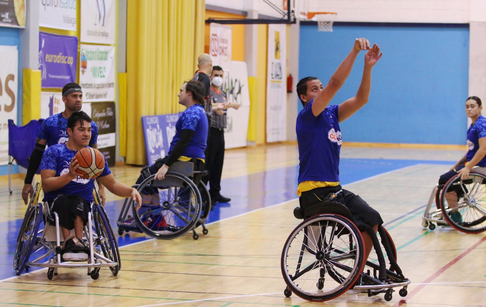 Partido de baloncesto en silla de ruedas: un jugador arma el lanzamiento en el pabellón