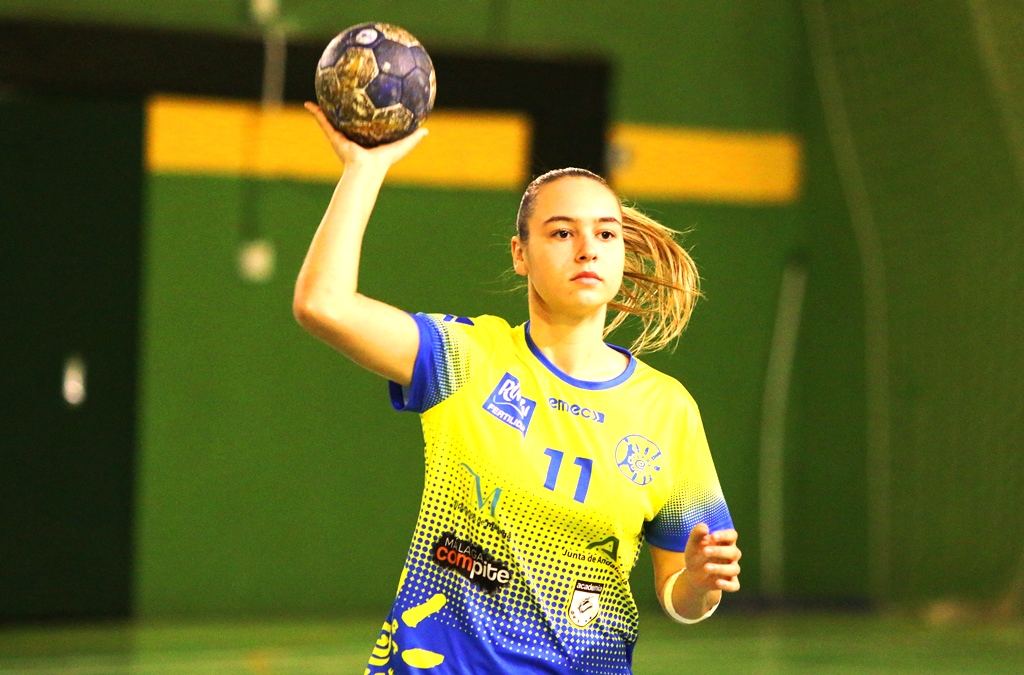 Jugadora de balonmano con el dorsal 11 arma el brazo para lanzar