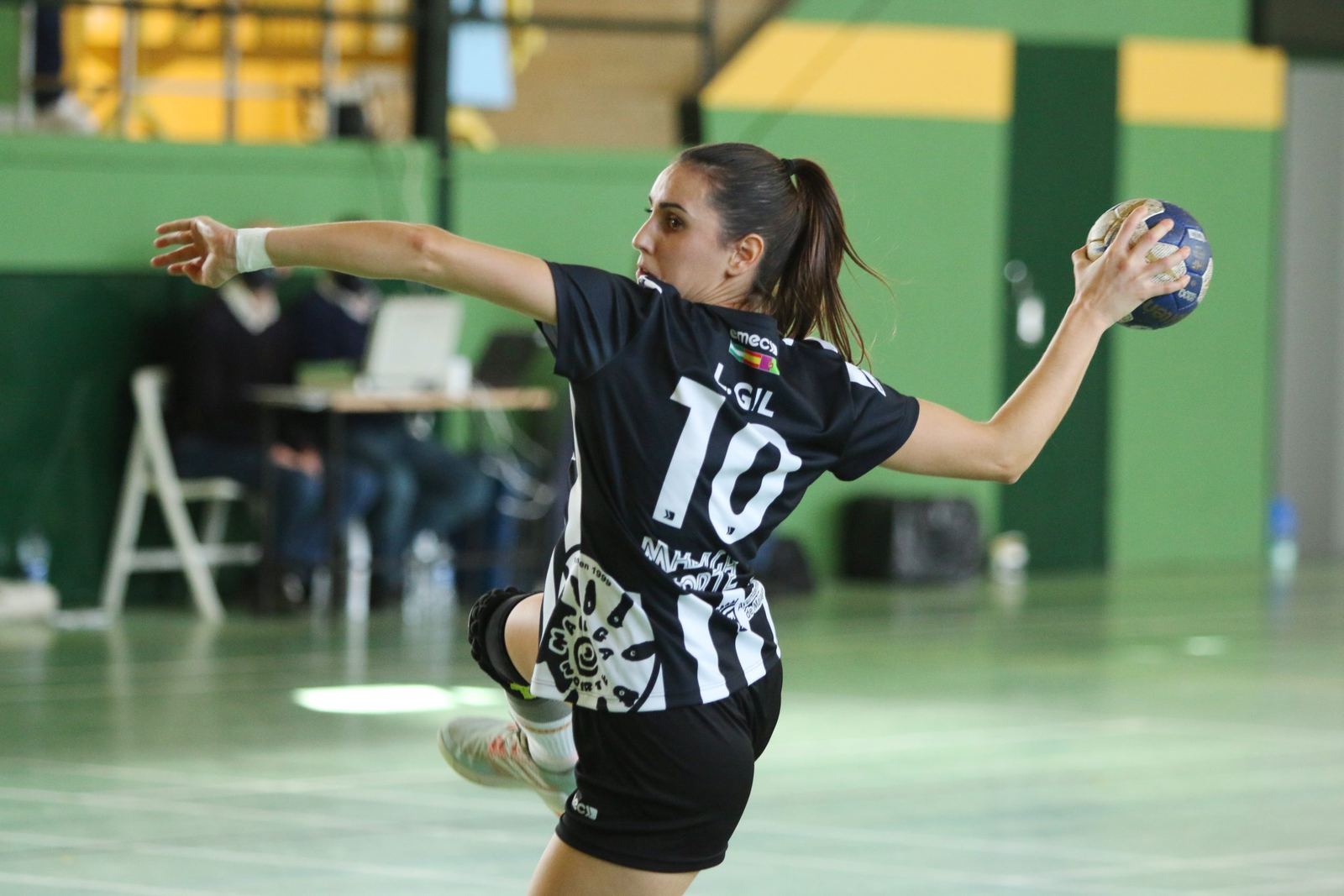Jugadora de balonmano con el dorsal 10 se eleva para lanzar