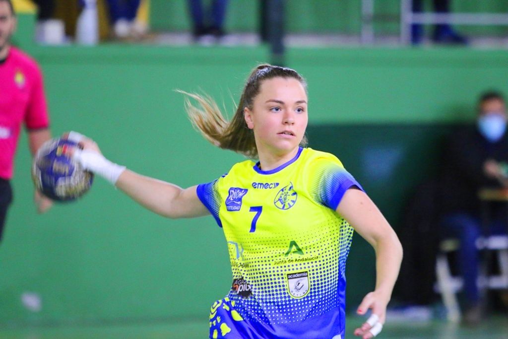 Jugadora de balonmano con el dorsal 7 arma el brazo en carrera