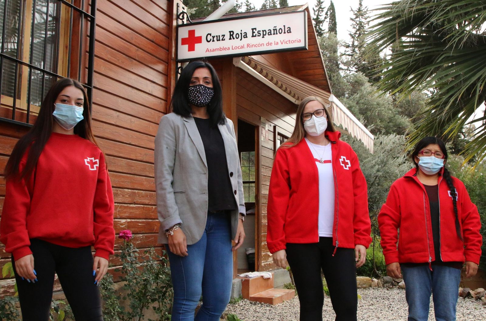 Cuatro personas ante la sede de Cruz Roja Española en Rincón de la Victoria