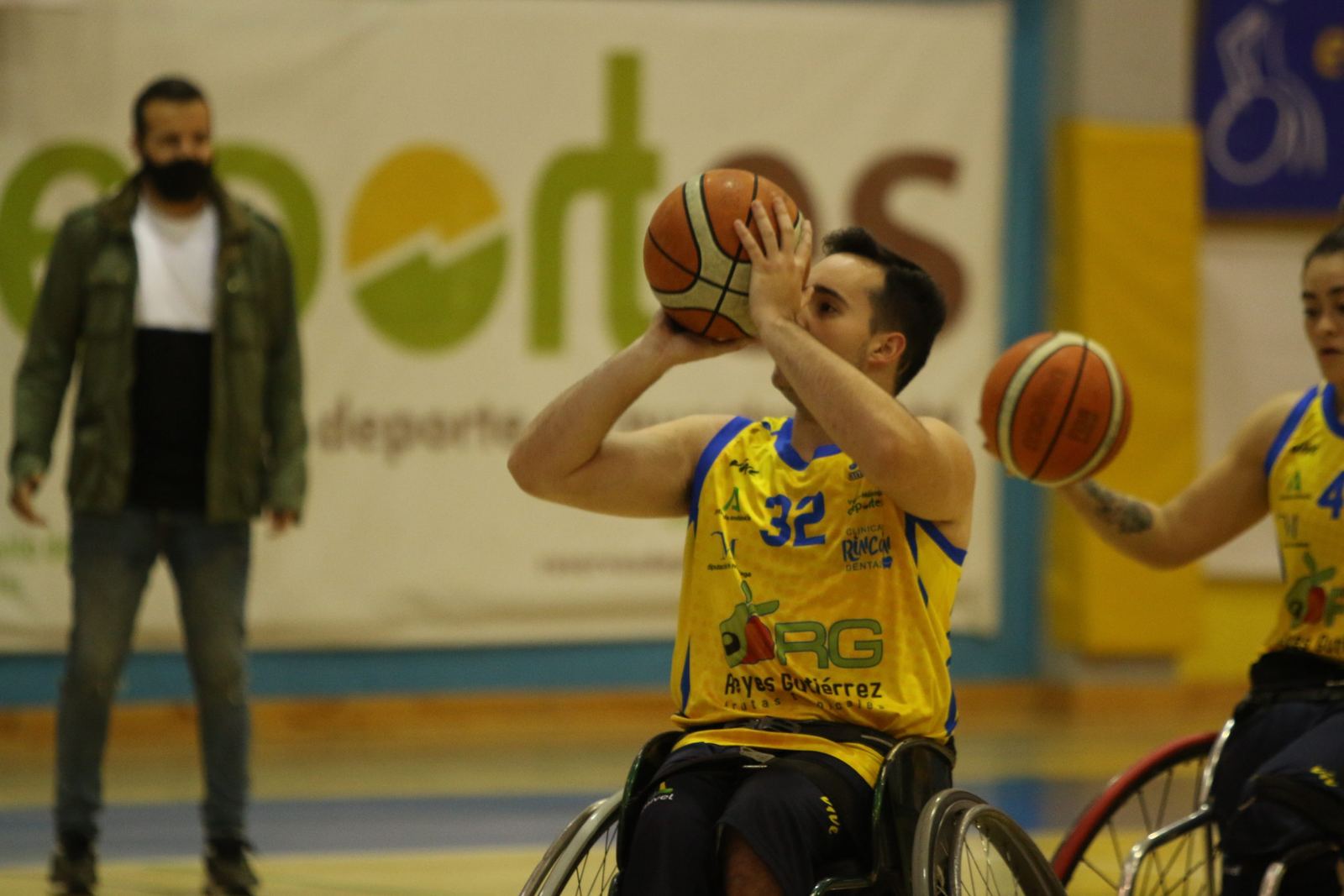 Un jugador de baloncesto en silla de ruedas lanza a canasta durante un entrenamiento