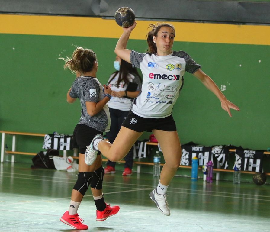 Jugadora de balonmano se eleva para lanzar ante la defensa