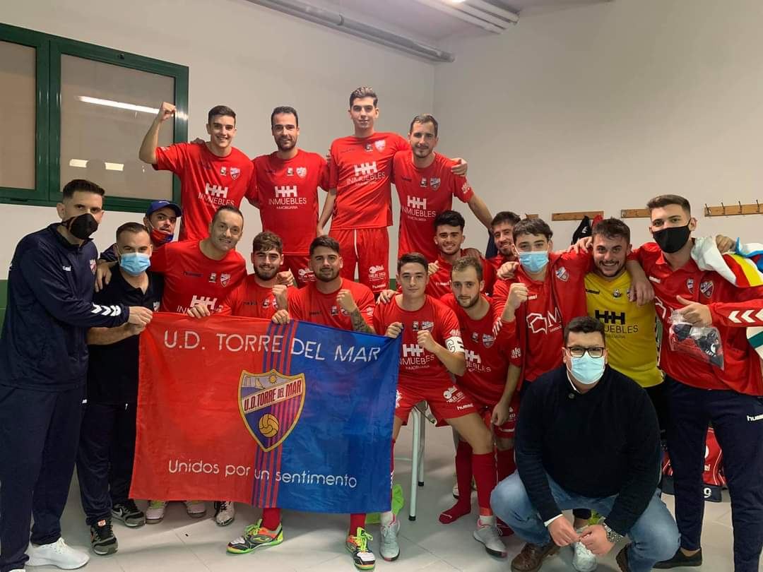 La plantilla de la U.D. Torre del Mar celebra en el vestuario con la bandera del club