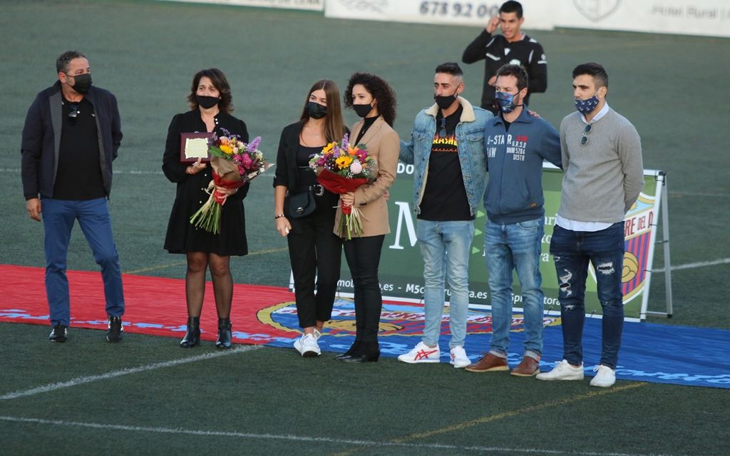 Acto de homenaje sobre el césped, con ramos de flores para las personas reconocidas