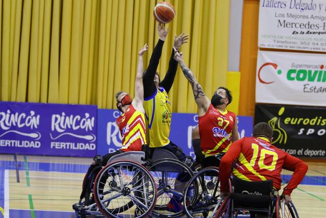 Salto por el balón en un partido de baloncesto en silla de ruedas, ante la valla de Rincón Fertilidad