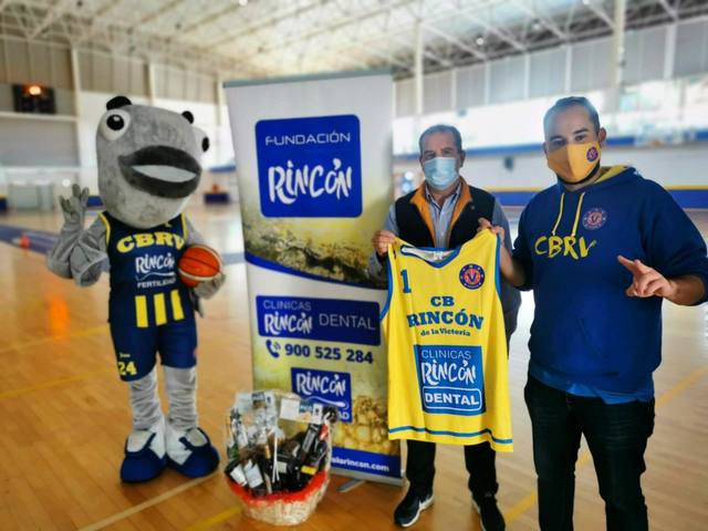 Entrega de la camiseta del C.B. Rincón de la Victoria junto a la mascota del club y el cartel de la Fundación Rincón