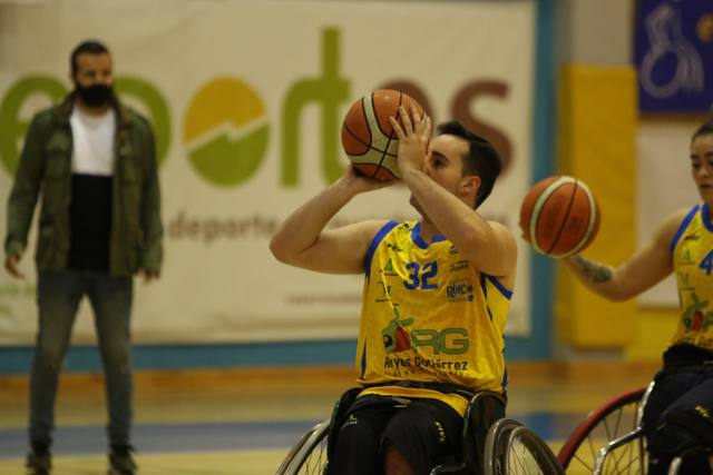 Un jugador de baloncesto en silla de ruedas lanza a canasta durante un entrenamiento