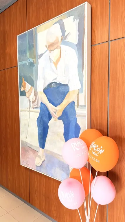 Globos de Rincón Salud junto a un cuadro en el pasillo del centro
